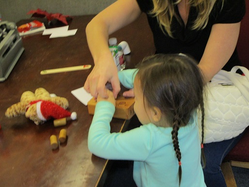 A mother and her blind child doing Braille